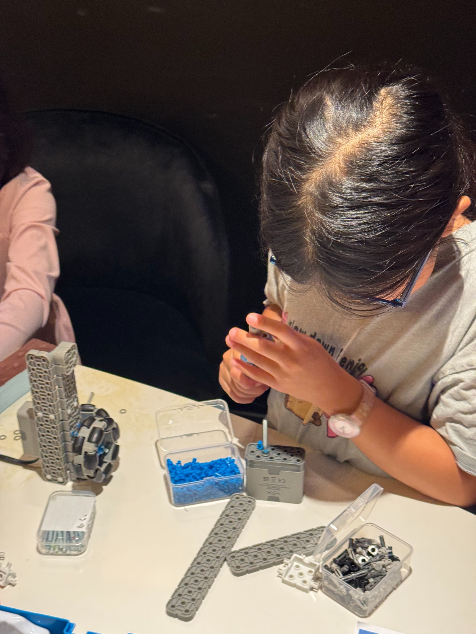 A student carefully assembling a robot mechanism
